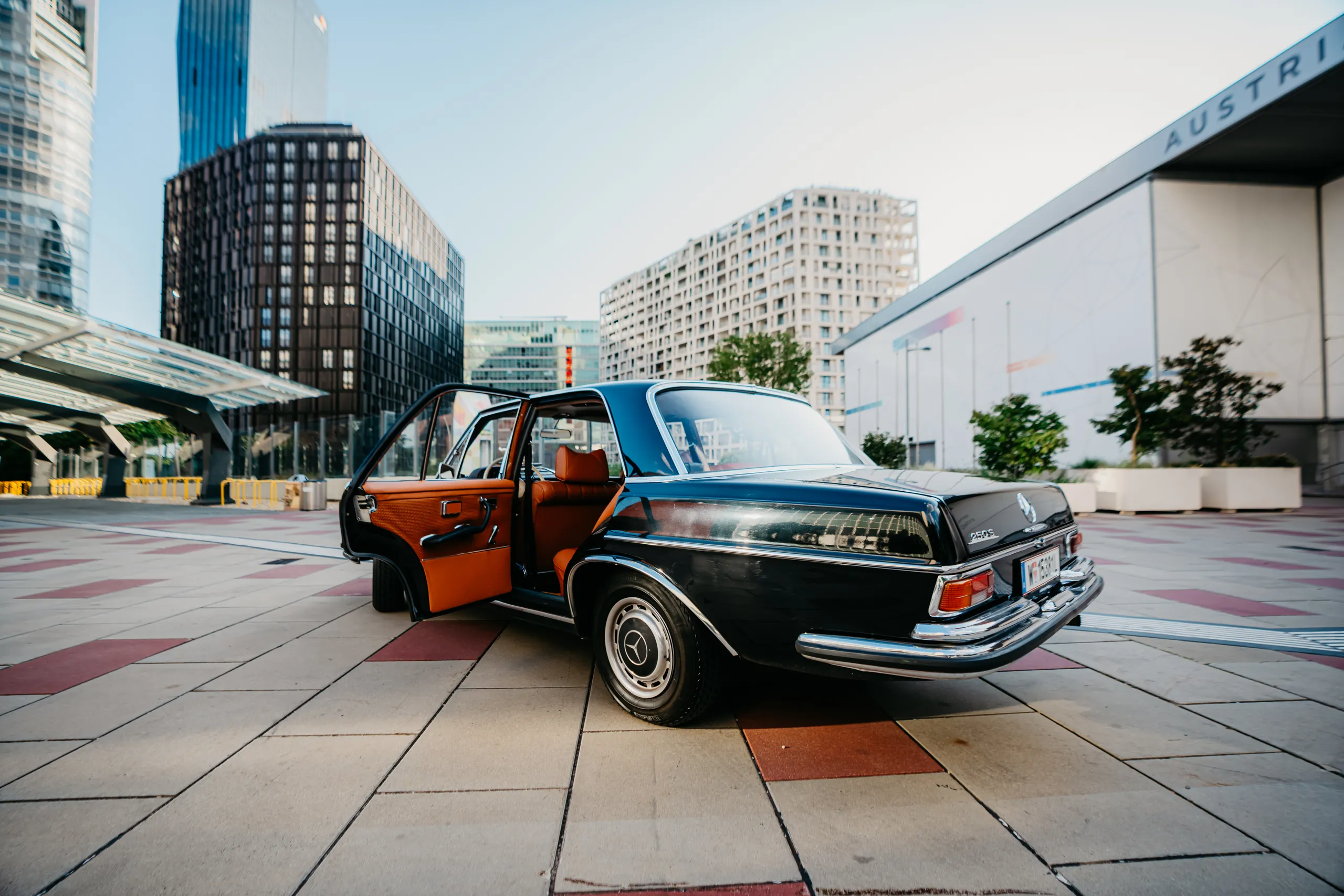 1967er Mercedes Oldtimer mit geöffneter Tür vor der Wiener Skyline