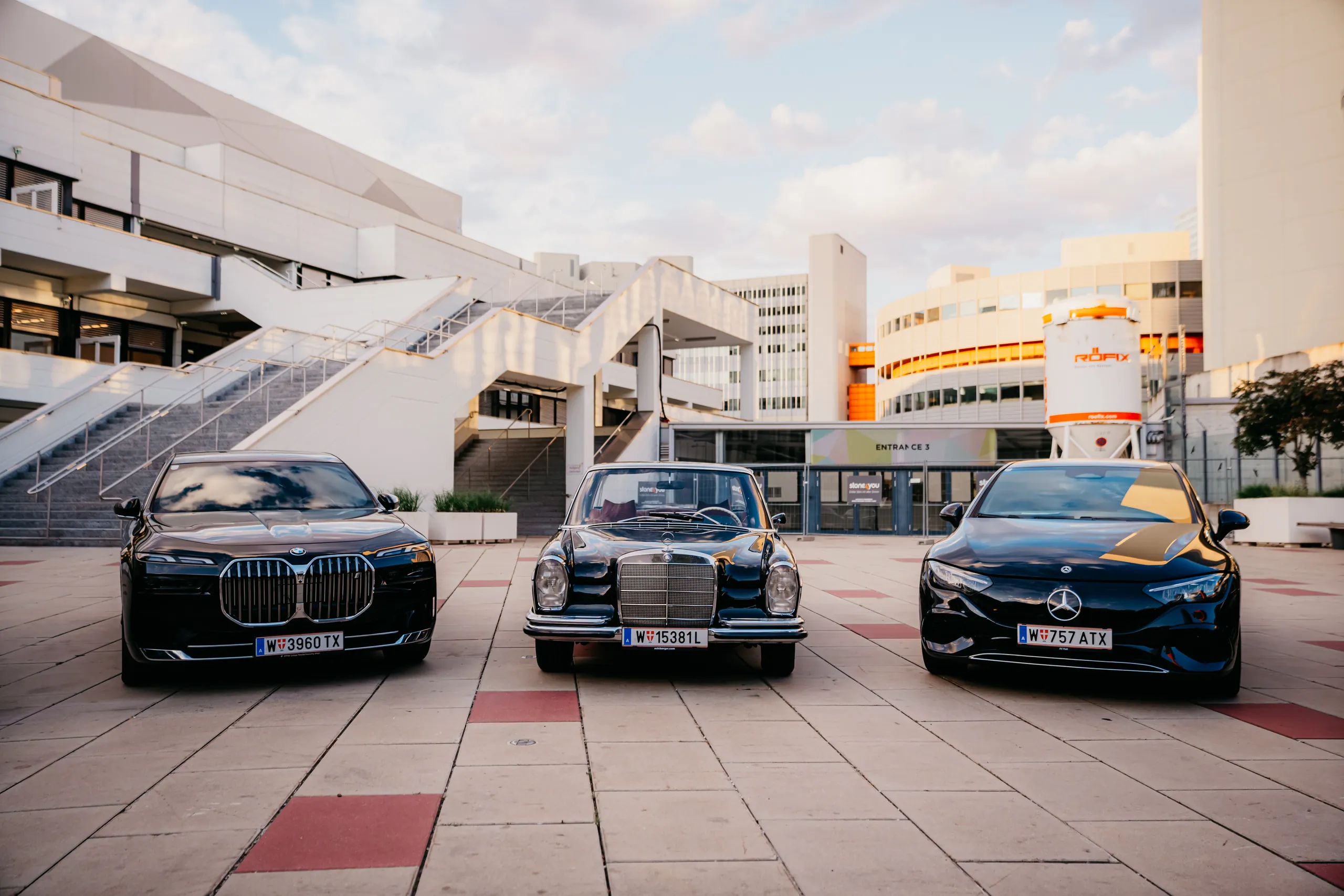 BMW i7, 1967er Mercedes Oldtimer und Mercedes EQE nebeneinander vor dem Austria Center Vienna